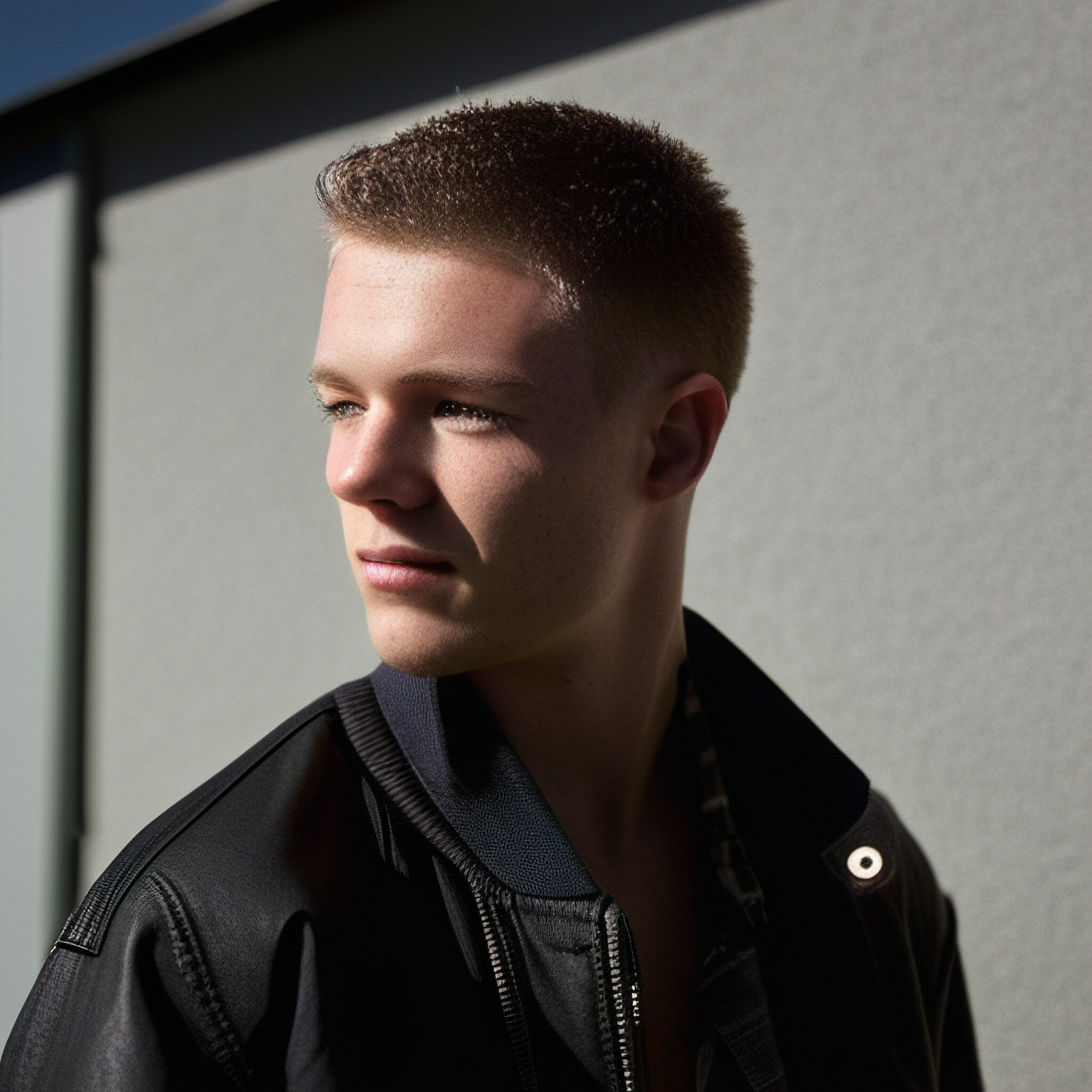 The low fade hairstyle is a versatile and stylish choice that can add a touch of sophistication to any look. In this image, the young man's hair is expertly cut to create a seamless transition from the shaved top to the longer hair on the back and sides. The subtle gradient fade adds texture and depth to the style, making it perfect for everyday wear or special occasions.