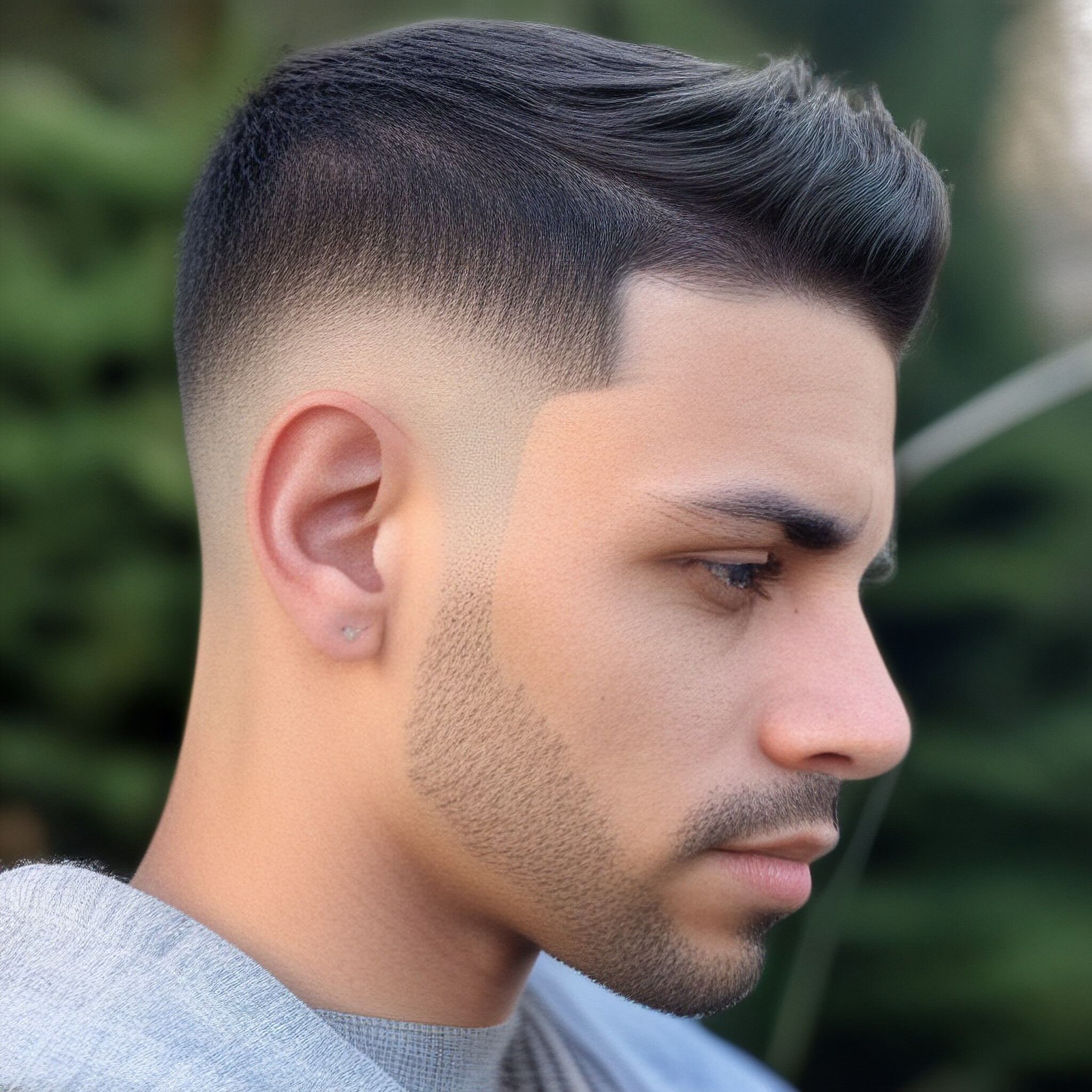 Get inspired by this stylish high fade haircut with textured and piecey hair on top.